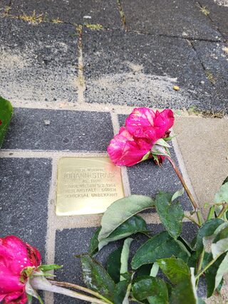 verlegter Stolperstein für Johann Strack mit Rosen