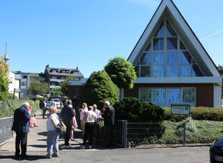 Gemeindemitglieder vor der neuapostolischen Kirche in Kenten